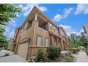 Inviting two-story townhome features a balcony, a garage, and mature landscaping at 10127 Bluffmont Ln, Lone Tree, CO 80124