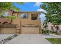 Two-story townhome with a garage and concrete driveway on a sunny day at 10127 Bluffmont Ln, Lone Tree, CO 80124