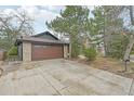 View of attached garage with brick and siding exterior and concrete driveway at 2026 S Pitkin St, Aurora, CO 80013