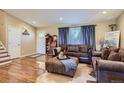 Cozy living room featuring hardwood floors, comfortable seating, and natural light from the window at 164 W Acoma Dr, Littleton, CO 80120