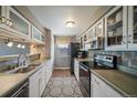 A well lit kitchen has a black refrigerator and dark wood colored floors at 7700 W Glasgow Pl # 19C, Littleton, CO 80128