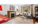 Cozy living room featuring a decorative fireplace, hardwood floors, and ample natural light at 1007 N Ogden St, Denver, CO 80218