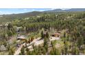 Expansive aerial view of the home nestled among dense trees on the property at 8600 S Warhawk Rd, Conifer, CO 80433