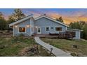 Charming home featuring a welcoming front deck and beautifully landscaped yard with mountain views at 11348 Ranch Elsie Rd, Golden, CO 80403