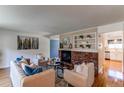 Bright living room featuring a brick fireplace, stylish decor, and hardwood floors at 6839 E Briarwood Dr, Centennial, CO 80112