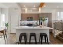 Bright kitchen with white countertops, island with seating, stainless steel appliances, and adjacent stairwell to other levels at 1239 Tennyson St # 10, Denver, CO 80204