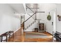 Spacious foyer with hardwood floors, a staircase, and a view into the living areas at 16662 W 61St Pl, Arvada, CO 80403