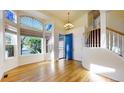 Bright foyer with hardwood floors, staircase, large windows and high ceilings that create a welcoming ambiance at 9567 W 107Th Dr, Broomfield, CO 80021