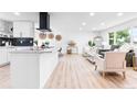 Open-concept kitchen and living space with modern white cabinetry, stainless steel appliances, and stylish furnishings at 544 S Victor Way, Aurora, CO 80012