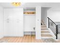 Bright mud room features custom storage, built-in bench, and easy access to the staircase with iron railing at 544 S Victor Way, Aurora, CO 80012