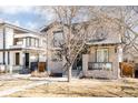 Attractive two-story home showcasing stone accents, a dark roof, a welcoming green entry door, and low maintenance landscaping at 2540 S Monroe St, Denver, CO 80210