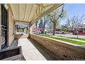 Inviting front porch with brick surround and shade from mature trees at 1111 S Corona St, Denver, CO 80210