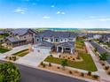 An aerial view of a home highlighting its three-car garage, landscaped yard, and location within a neighborhood at 9566 Poppy Way, Arvada, CO 80007
