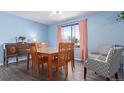 Dining room with hardwood table, four chairs, vintage sideboard, and pale blue walls at 15492 E Floyd Ave, Aurora, CO 80013