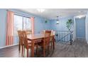 Dining room with hardwood table, chairs, black railing, and pale blue walls at 15492 E Floyd Ave, Aurora, CO 80013