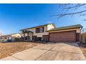 Split-level home with front lawn and driveway to the attached garage at 15492 E Floyd Ave, Aurora, CO 80013