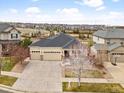 Aerial view of a tan home with stone accents and a three-car garage near a park at 6031 S Irvington Ct, Aurora, CO 80016