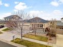 Aerial view of a tan home with stone accents and a two-car garage at 6031 S Irvington Ct, Aurora, CO 80016