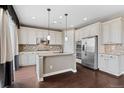 Spacious kitchen with white cabinets, a center island, and stainless steel appliances at 6031 S Irvington Ct, Aurora, CO 80016