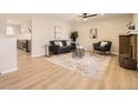 Bright living room with hardwood floors, a modern ceiling fan, and an open concept to the kitchen at 709 S Alkire St, Lakewood, CO 80228