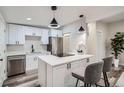 Modern kitchen with stainless steel appliances, quartz countertops, and a center island with pendant lighting at 3656 Fairfax St, Denver, CO 80207