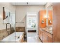 Modern bathroom boasting a soaking tub, glass shower, dual vanity, and wooden cabinets at 7600 Landmark Way # 904, Greenwood Village, CO 80111