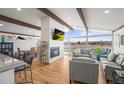 Spacious living room features a fireplace, exposed beams, a wall of windows, and views of the water at 2300 Willow Ln, Lakewood, CO 80215