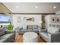 Cozy living room with a comfortable gray sofa, two chairs, an ottoman, and tranquil water views at 2300 Willow Ln, Lakewood, CO 80215