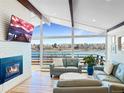 Bright living room features a fireplace, exposed beams, a wall of windows, and views of the water at 2300 Willow Ln, Lakewood, CO 80215