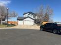 A two-story home with a three-car garage, complemented by a well-manicured front yard at 19987 E Belleview Pl, Centennial, CO 80015