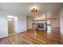 Open floor plan with hardwood floors, fireplace, and a view into the kitchen at 1705 Stonehenge Dr, Lafayette, CO 80026