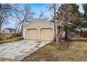 House exterior featuring a two-car garage, a well-maintained lawn and mature trees surrounding the property at 11623 W Hornsilver Mtn, Littleton, CO 80127