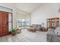 Bright living room with large windows, vaulted ceilings, and patterned furnishings at 4022 S Kalispell St, Aurora, CO 80013
