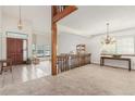 Open-concept living area with a staircase, tiled entry, and chandelier lighting at 4022 S Kalispell St, Aurora, CO 80013