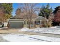 Charming single-Gathering home featuring a front porch, attached garage, and snow-covered front yard in a residential neighborhood at 1894 S Marshall Cir, Lakewood, CO 80232