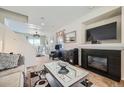 Cozy living room featuring a fireplace and seamless open floor plan to the dining area at 5541 Killarney Ct, Denver, CO 80249
