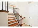 Elegant staircase with wood railings and white risers leads to the upper level of the home at 9905 Foxhill Cir, Highlands Ranch, CO 80129