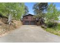 Charming mountain home with a two-car garage and a welcoming driveway at 32171 Lodgepole Dr, Evergreen, CO 80439