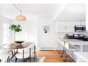 Bright dining area features an oval table, modern chairs, wood floors, and seamlessly connects to the kitchen at 6842 W Eldorado Pl, Lakewood, CO 80227