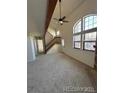 Bright living room with high ceilings, large windows, and a staircase to the upper level at 942 S Walden St # 206, Aurora, CO 80017