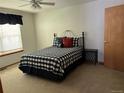 Bedroom features a bed with black and white comforter, a ceiling fan, and light carpet at 9724 W Euclid Dr, Littleton, CO 80123
