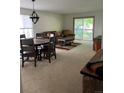A spacious living room with carpet flooring, dining table and chairs, couch and sliding glass door to a deck at 9724 W Euclid Dr, Littleton, CO 80123