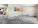 An empty living room with a connecting kitchen area with light green accents at 3108 Quari St, Aurora, CO 80011