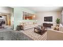A furnished living room with sofa, chairs, TV, and an area rug at 3108 Quari St, Aurora, CO 80011