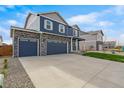 Charming two-story home featuring a three-car garage, stone accents and a well-manicured lawn at 13477 Valentia St, Thornton, CO 80602