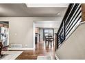 Welcoming foyer with hardwood floors, staircase, and an open view into the adjacent kitchen and dining room at 6227 Shenandoah Ave, Firestone, CO 80504