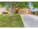 Inviting home featuring a well-maintained lawn, a two-car garage, and a classic brick and siding facade at 8845 W 81St Dr, Arvada, CO 80005