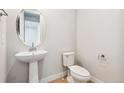 Elegant half-bathroom with a pedestal sink, modern fixtures, and a neatly placed toilet at 1825 Morgan Dr, Erie, CO 80516