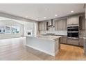 Open-concept kitchen with large island, stainless steel appliances, and abundant cabinet space at 1825 Morgan Dr, Erie, CO 80516