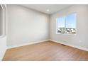 Bright, versatile room with light hardwood flooring and a large window offering neighborhood views at 1825 Morgan Dr, Erie, CO 80516